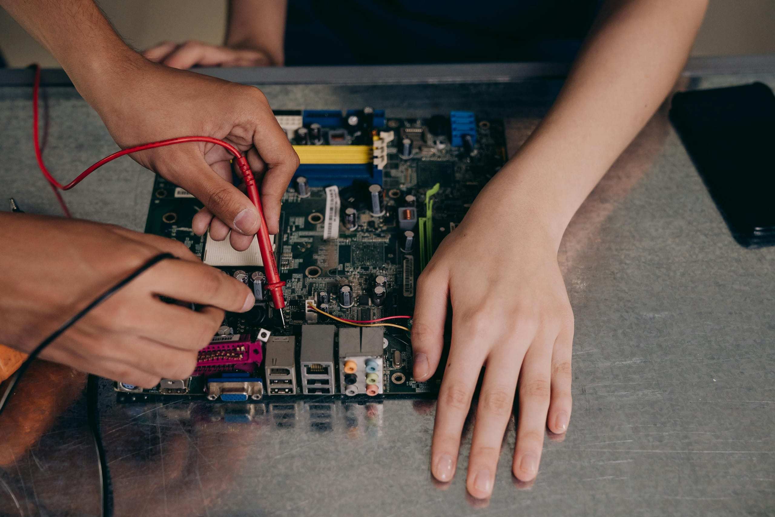 A multimeter probe on a mainboard, close in